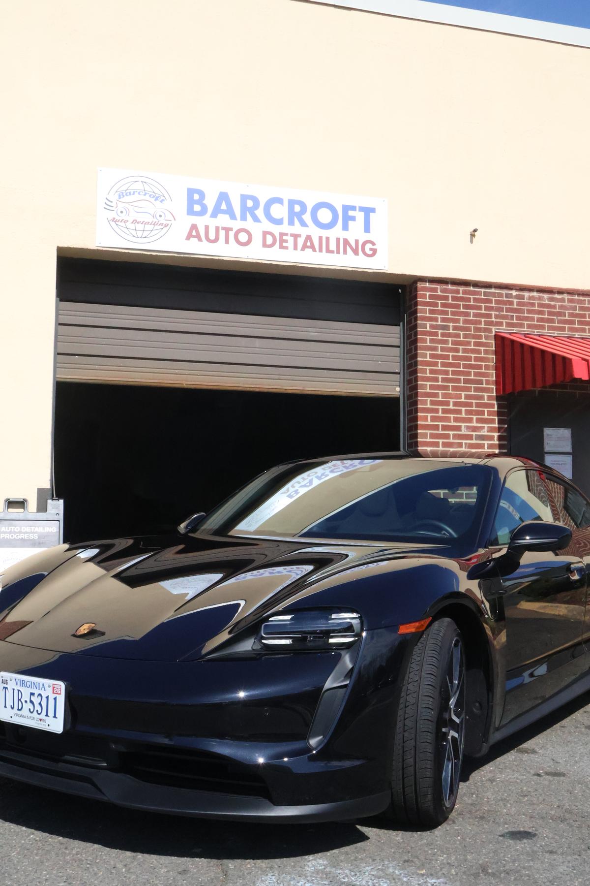 Luxury vehicle with professional ceramic coating application showing hydrophobic water beading effect